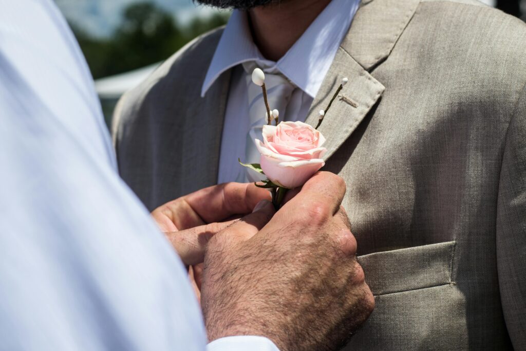 Bestman fäster corsage på brudgum